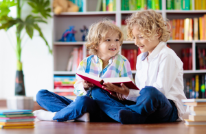 Pakiet ćwiczeń czytanie ze zrozumieniem. Radosne dzieci czytają książkę.
